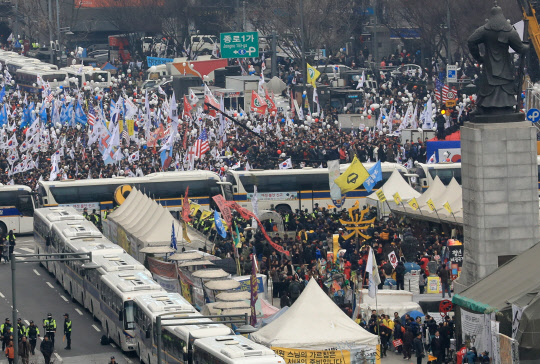 경찰버스 사이에 두고      (서울=연합뉴스) 서명곤 기자 =  1일 오후 서울 광화문광장  남측 세종대로에서 '대통령 탄핵 기각을 위한 국민총궐기 운동본부' 주최로 열린 '제15차 태극기 집회'에서 집회 참가자들이 탄핵 기각을 요구하며 구호를 외치고 있다. 탄핵 인용을 촉구하는 '박근혜정권 퇴진 비상국민행동'(퇴진행동)은 오후 5시 광화문 광장에서 '박근혜 구속 만세! 탄핵인용 만세! 박근혜 퇴진 18차 범국민행동의 날' 집회를 연다.    2017.3.1      seephoto@yna.co.kr  (끝)